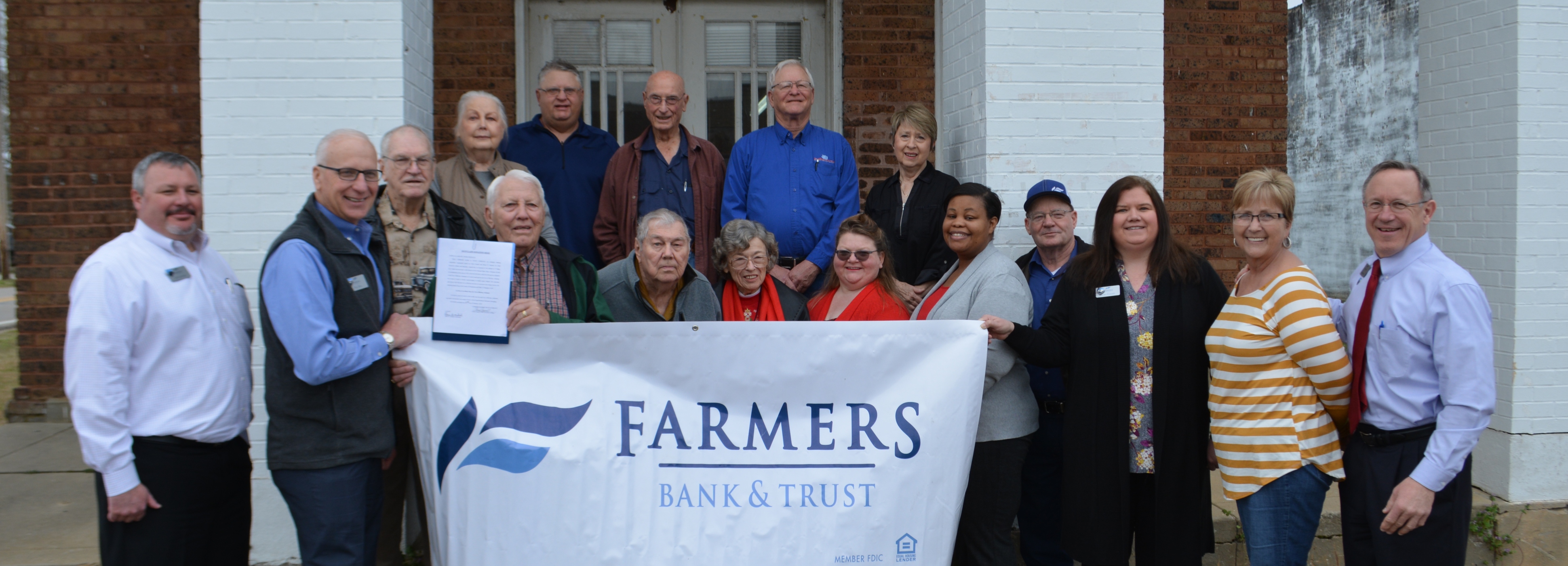People smiling outside when FB&T deeds building to city in Blevins, AR